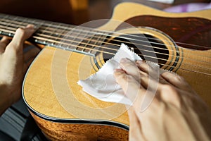 Cleaning acoustic guitar with microfiber cloth