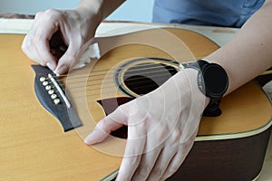 Cleaning acoustic guitar on wooden table