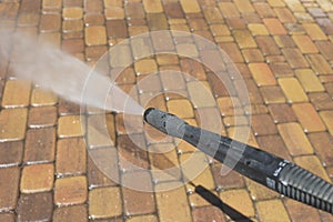 Cleaning backyard paving tiles with high pressure washer. Spring clean up. Cleaning dirty backyard paving tiles with