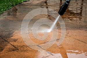 Cleaning backyard paving tiles with pressure washer