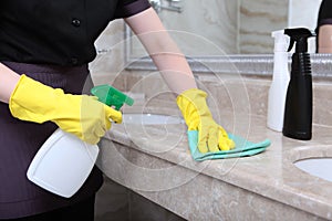 Cleaning the bathroom in an expensive hotel. Marble surface. An unrecognizable photo. The concept of cleanliness and hygiene. Copy