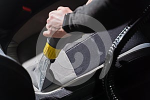 Cleaning car salon dry cleaning with vacuum cleaner. Professional use of a steam vacuum cleaner to remove stains.