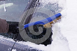Cleaning the car from snow in winter. Snow-covered car after a snowfall. Deteriorating weather conditions in winter, Winter Snow