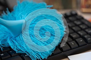 Cleaning and caring computer keyboard with a blue brush from dust