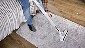 Cleaning the carpet on the floor with a vacuum cleaner from dust.