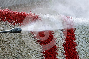 Cleaning the carpet with a gun for washing high pressure water. House cleaning.