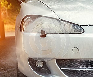 Cleaning cars headlight with steam radiator at car wash