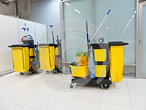 Cleaning Cart in the station. Cleaning tools cart and Yellow mop bucket wait for cleaning.Bucket and set of cleaning equipment