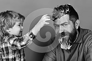 Cleaning and cleanliness. Man with beard and smiling child plays with soap suds.