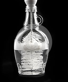Cleaning a clear transparent glass bottle with special round bottle cleaning tool.