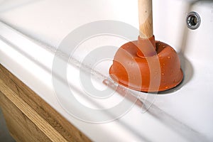 Cleaning the clogged sink with a plunger