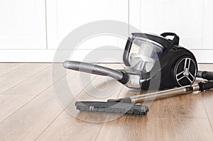 cleaning concept. Black vacuum cleaner stands on the floor in the apartment