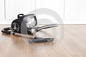 cleaning concept. Black vacuum cleaner stands on the floor in the apartment