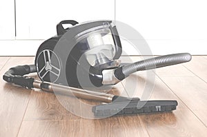 cleaning concept. Black vacuum cleaner stands on the floor in the apartment