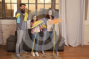 Cleaning day. Family mom dad and daughter with cleaning supplies at living room. We love cleanliness and tidiness