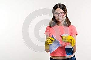 Cleaning day, spring cleanup, housework concept. Girl teenager in yellow gloves with rag and spray detergent.