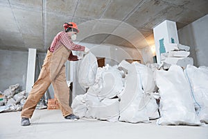 Worker collecting construction waste in bag