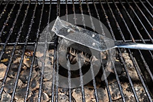 Cleaning a dirty grill while standing on the terrace and emptying the ashes.