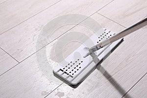 Cleaning dirty parquet floor with mop indoors. Space for text
