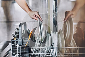 Cleaning dishes in the dishwasher.