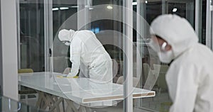 Cleaning, disinfection and people with hazmat suit in laboratory for germs, virus exposure or prevent infection