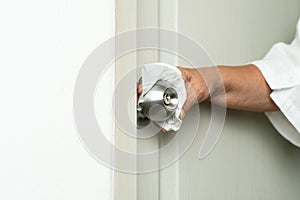 Cleaning door knob with alcohol spray for Covid-19 Coronavirus prevention