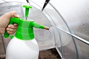 Cleaning the empty greenhouse with an antibacterial cleaner liquid.