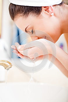 Cleaning face in the bathroom with water