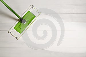 Cleaning floor with mop top view on white wooden background photo