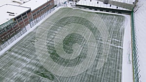 Cleaning the football field from snow. Snow falling on a football field. A machine that cleans the snow on a football
