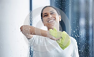 Cleaning, glass and hygiene with a black woman using a cloth or rag while wiping a window in an office. Cleaner, janitor