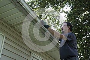 Cleaning Gutters Of Leaves And Sticks