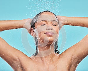 Cleaning hair, shower and woman in studio for skincare, hygiene or wellness isolated on blue background. Water, face and