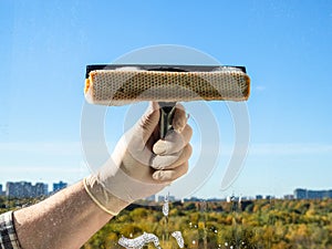 cleaning a home window glass in sunny autumn day