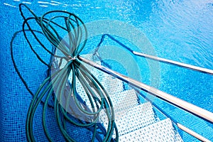 Cleaning hose in the water of a swimming pool, during cleaning work and preparation for the summer bathing season