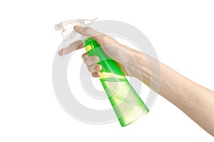 Cleaning the house and cleaner theme: man's hand holding a green spray bottle for cleaning isolated on a white background