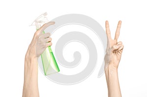 Cleaning the house and cleaner theme: man's hand holding a green spray bottle for cleaning isolated on a white background