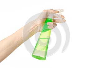 Cleaning the house and cleaner theme: man's hand holding a green spray bottle for cleaning isolated on a white background