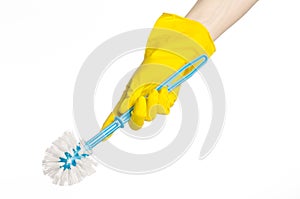 Cleaning the house and cleaning the toilet: human hand holding a blue toilet brush in yellow protective gloves isolated on a white