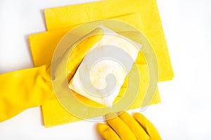 Cleaning the house and sanitation topic: Hand holding a yellow sponge wet with foam isolated on a white background in