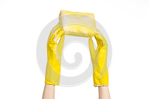 Cleaning the house and sanitation topic: Hand holding a yellow sponge wet with foam isolated on a white background in studio