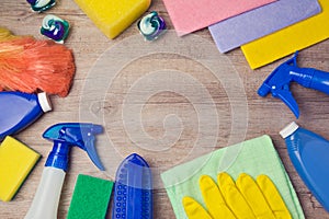 Cleaning and household concept with supplies on wooden background. View from above