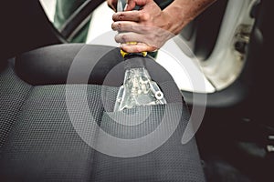 Cleaning interior of modern car. Details of upholstery vacuuming