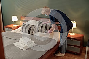 Cleaning lady doing housekeeping and making bed in hotel room. Cleaning service concept