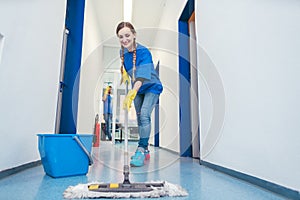 Cleaning lady mopping the floor in an office building