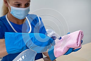 A cleaning lady prepares a cloth and agents for cleaning