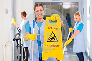 Cleaning lady showing warning sign