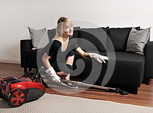 Cleaning lady is vacuuming couch