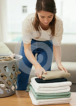 Cleaning, laundry and housekeeping with woman in living room for towels, fabric and chores. Cotton, maintenance and