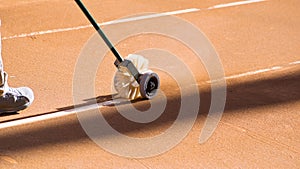 Cleaning the lines on a clay tennis court